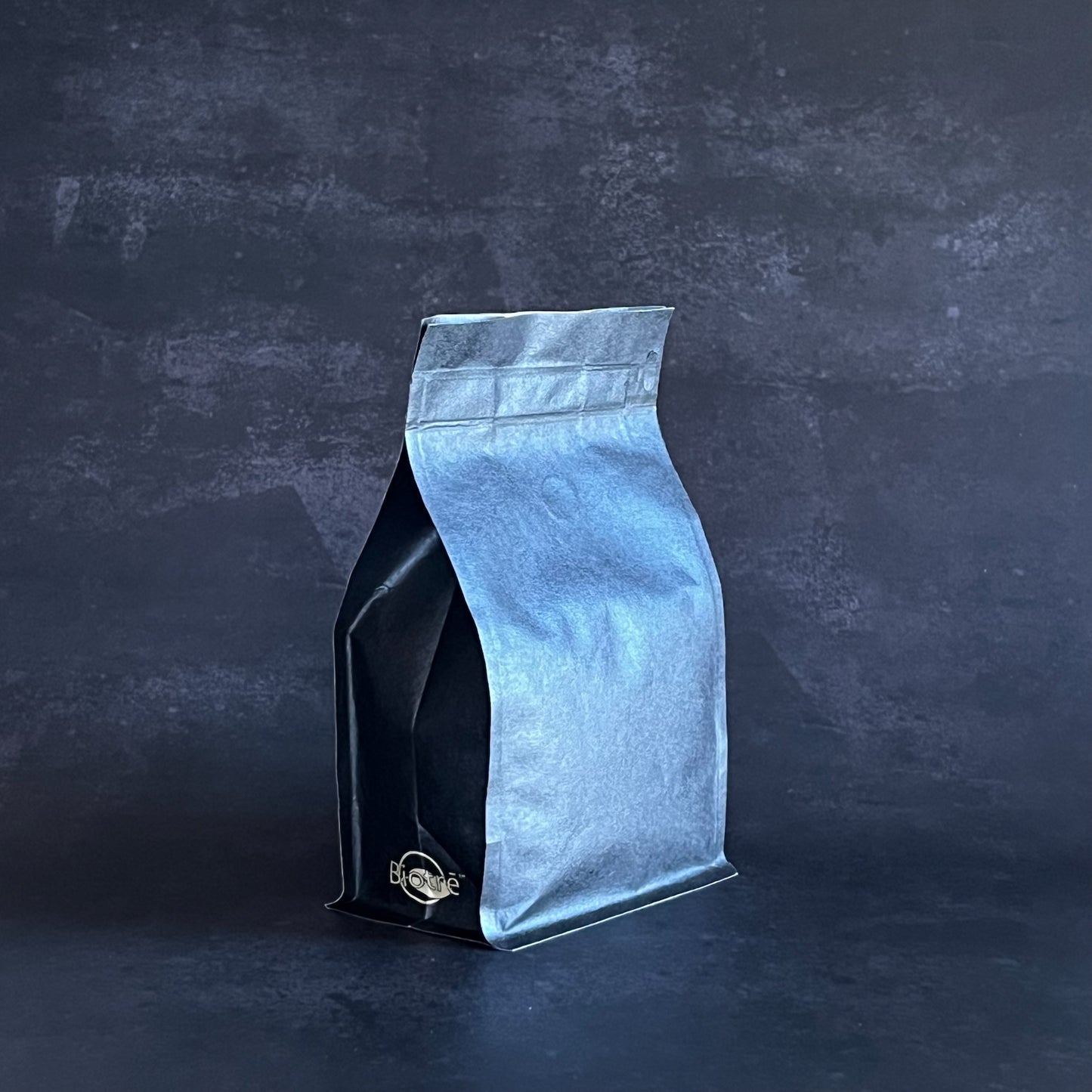 Black and blue coffee bag on a dark textured background